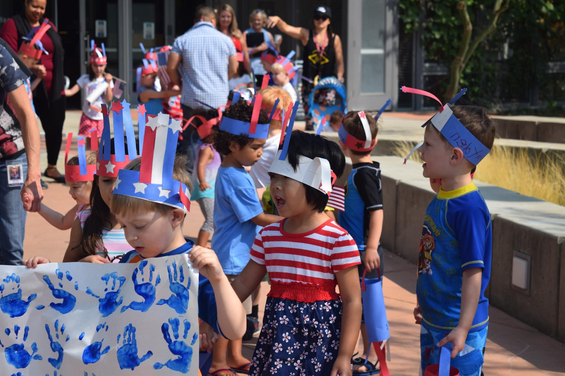 7月4日，“学天梯”幼儿园的孩子们齐聚市政厅，戴着手工制作的帽子，举着手工制作的旗帜